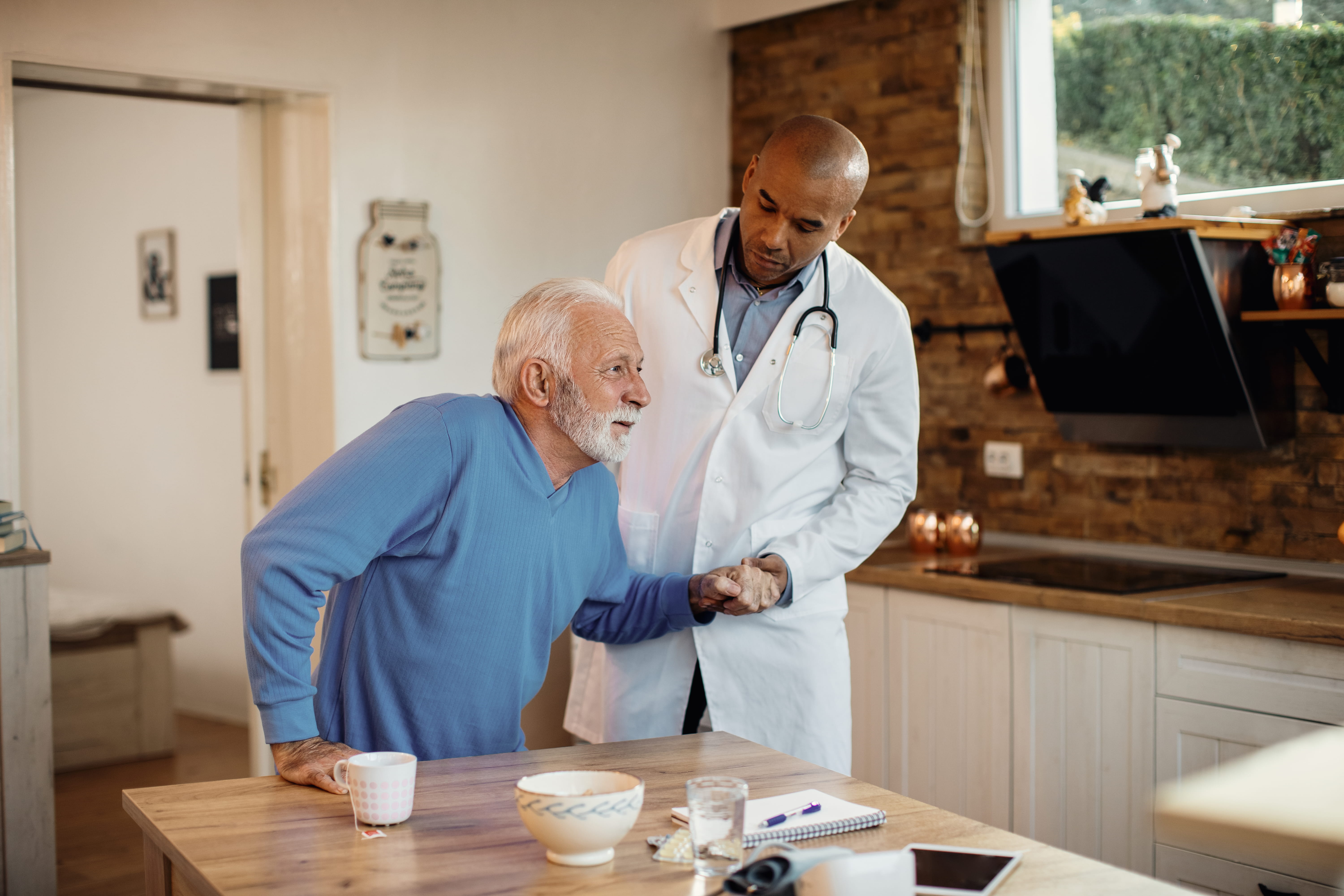Care professional helping a senior stand at home